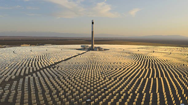 Centrale solaire thermodynamique à concentration (CSP) avec sa tour centrale et ses miroirs, au coucher du soleil